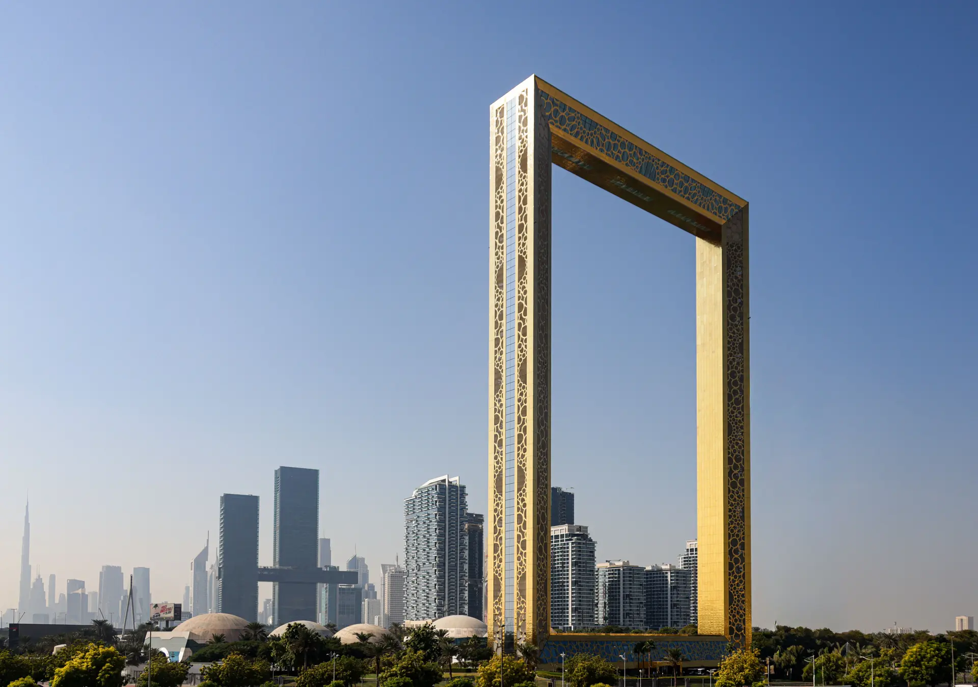 The Dubai Frame, a gold rectangle standing above the city with the towers behind it.