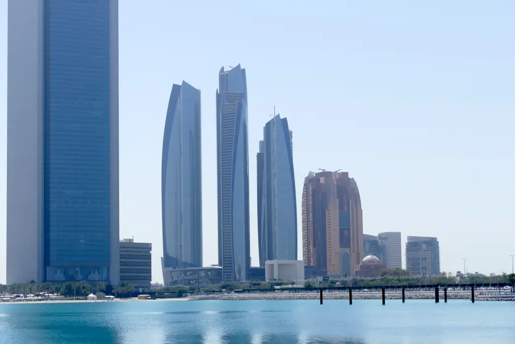 The Abu Dhabi skyline reflected over calm water.