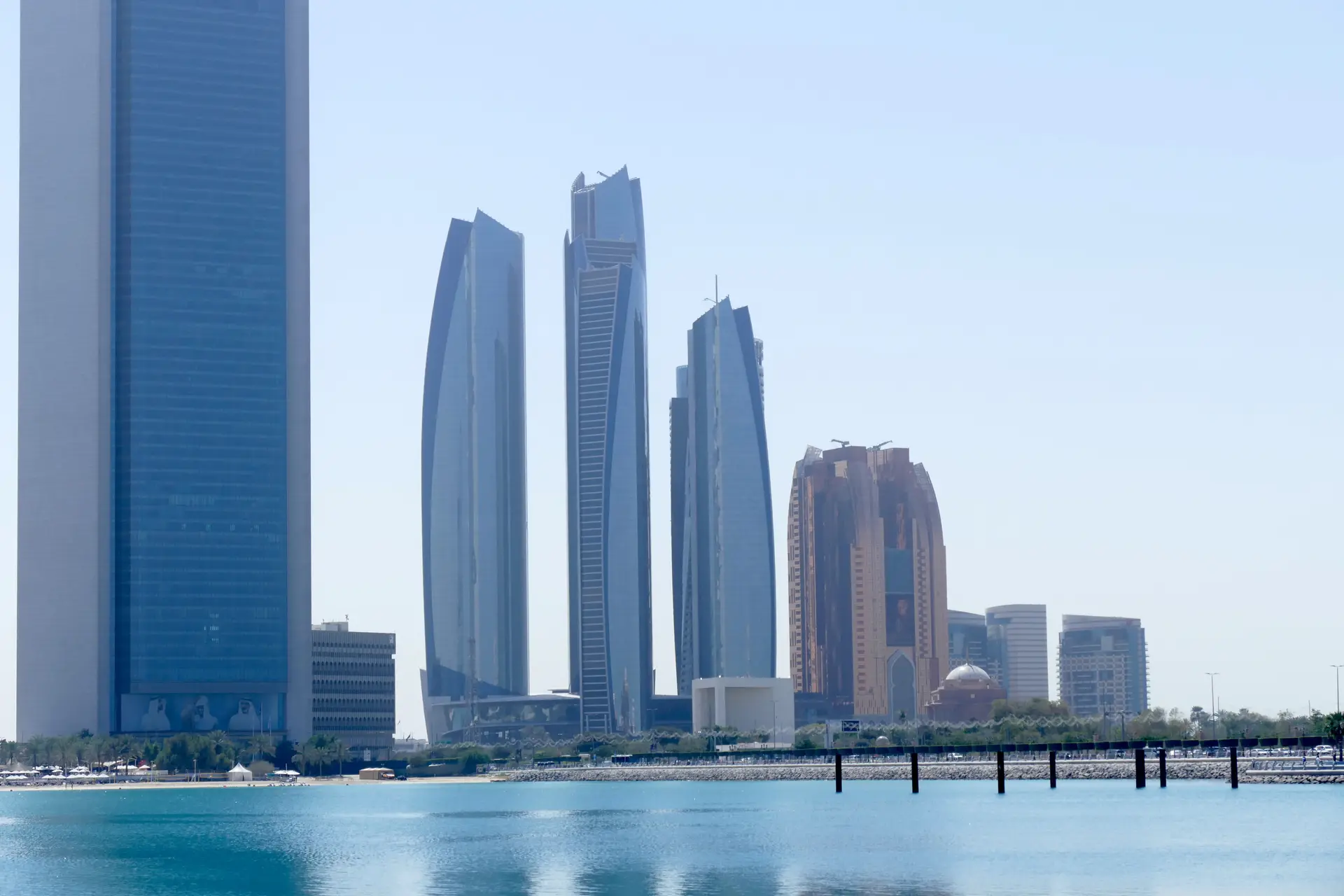 The Abu Dhabi skyline reflected over calm water.