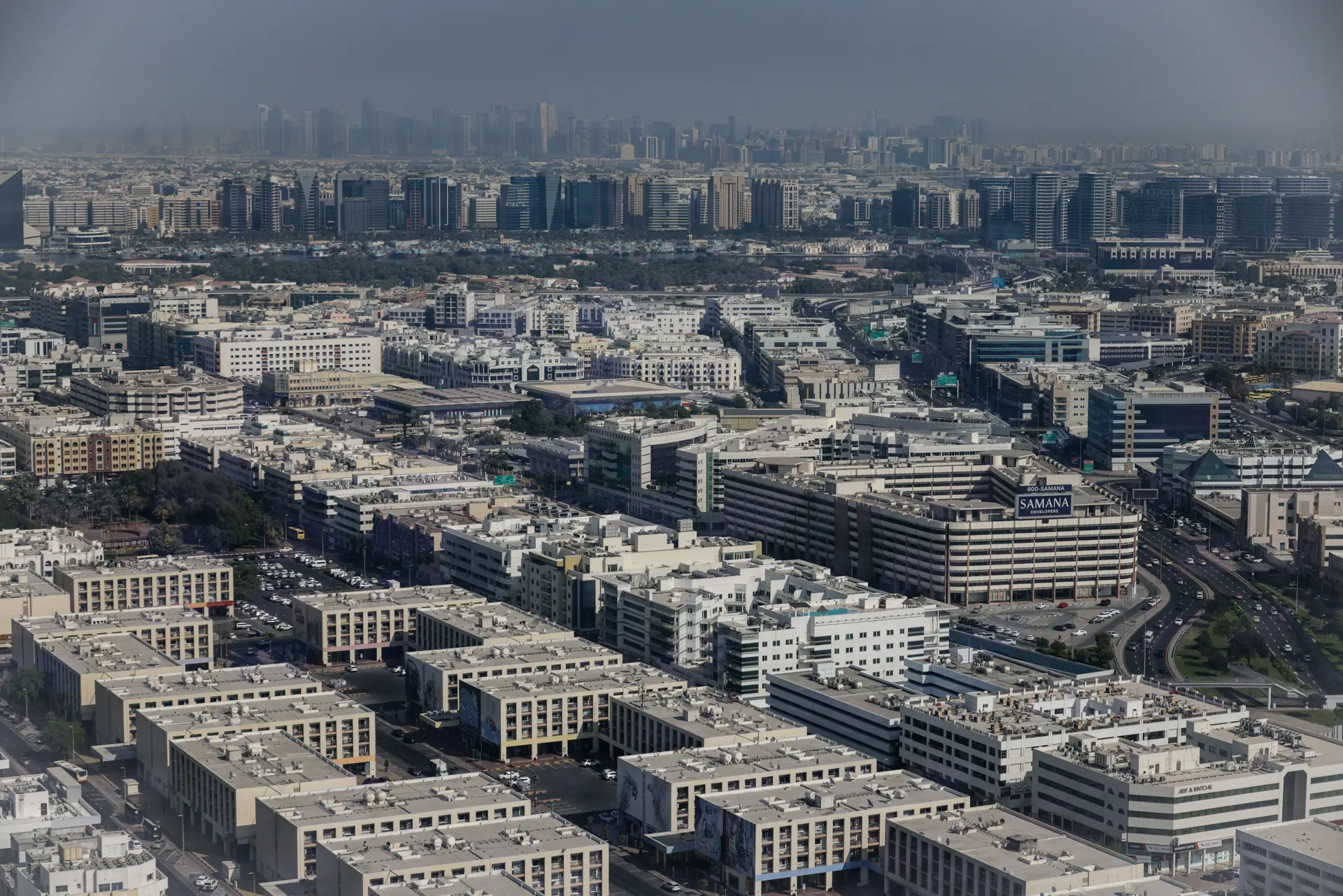 Dubai from the air, low-rise blocks and towers packed close together.