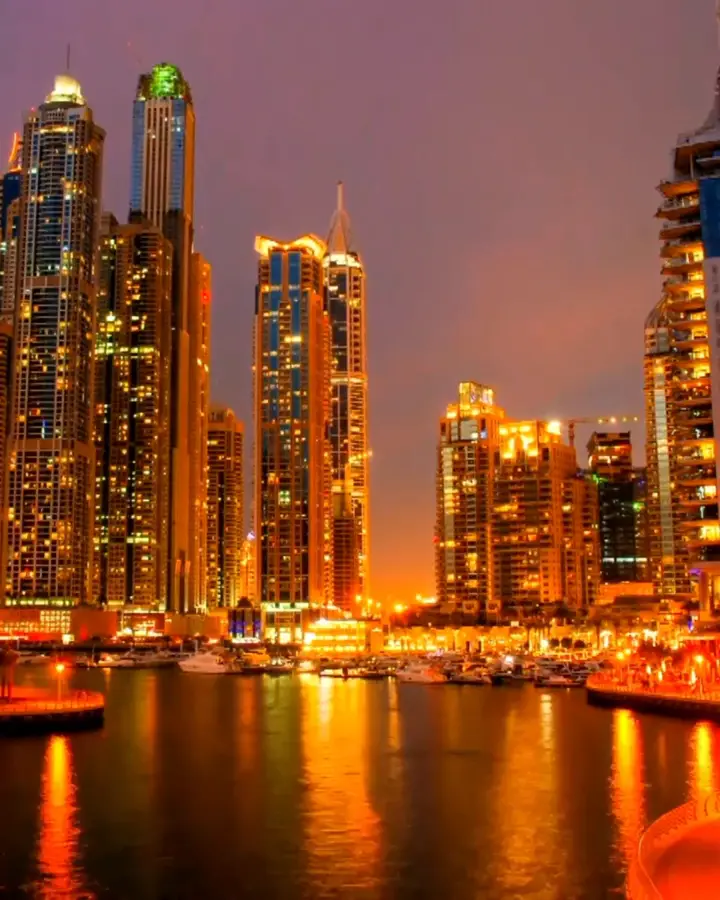 Dubai Marina at night, the towers lit and reflected on the water